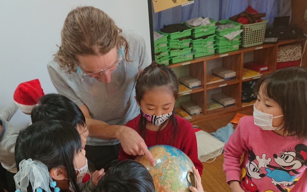 Roman and kids pointing Israel on the globe